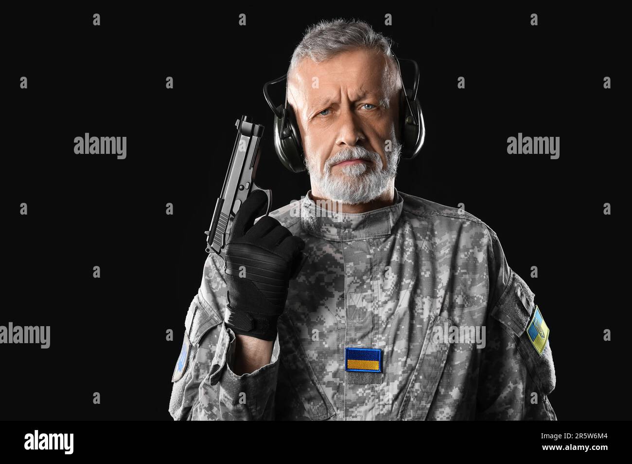 Ukrainian soldier in headphones with gun on dark background Stock Photo ...