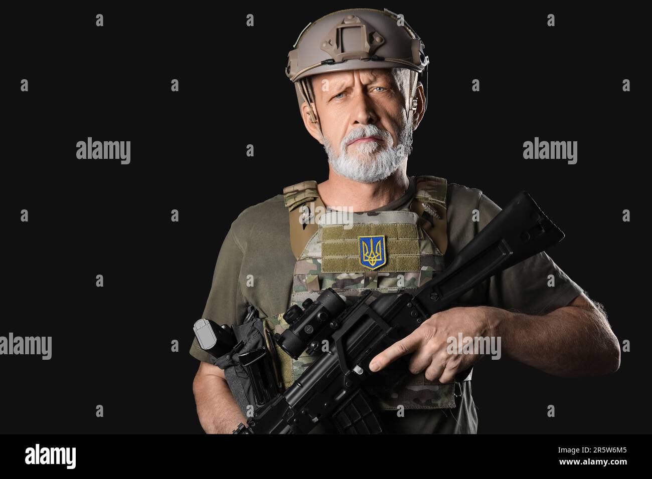 Ukrainian soldier with assault rifle on dark background Stock Photo - Alamy