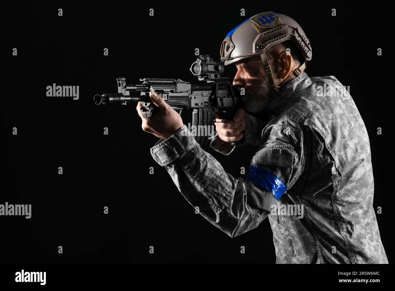 Ukrainian soldier with assault rifle on dark background Stock Photo - Alamy