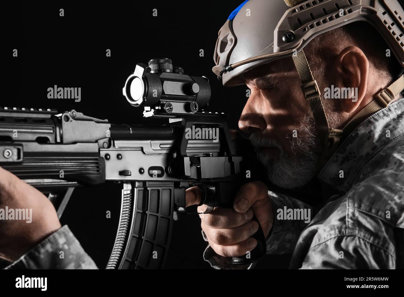 Ukrainian soldier with assault rifle on dark background, closeup Stock ...