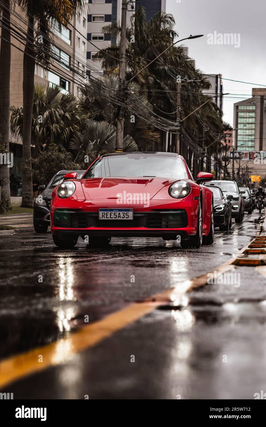 A Porsche 911 Carrera S in Carmin Red, front view in a rainy day setting Stock Photo
