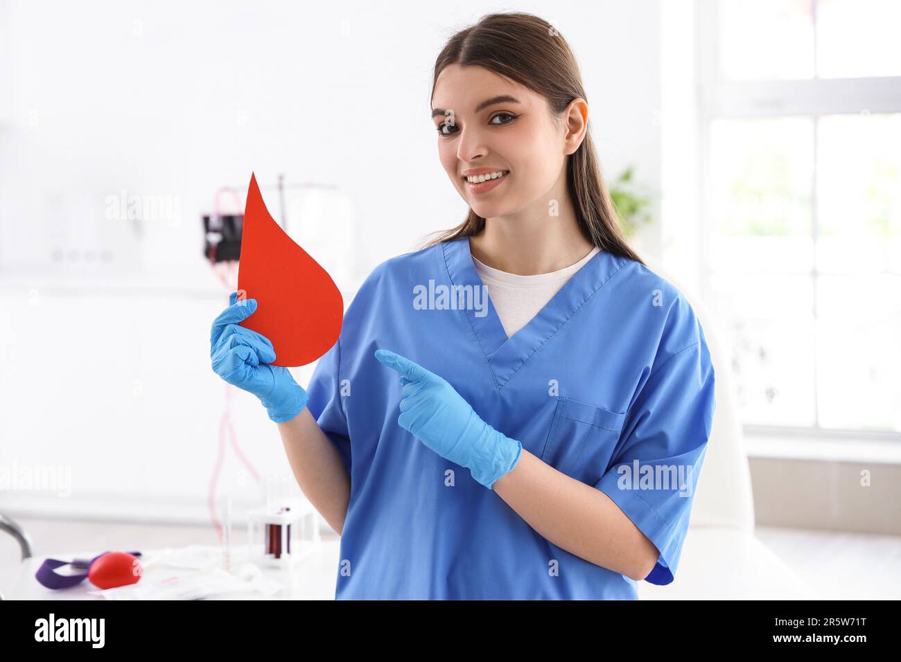Female nurse pointing at paper blood drop in clinic Stock Photo - Alamy