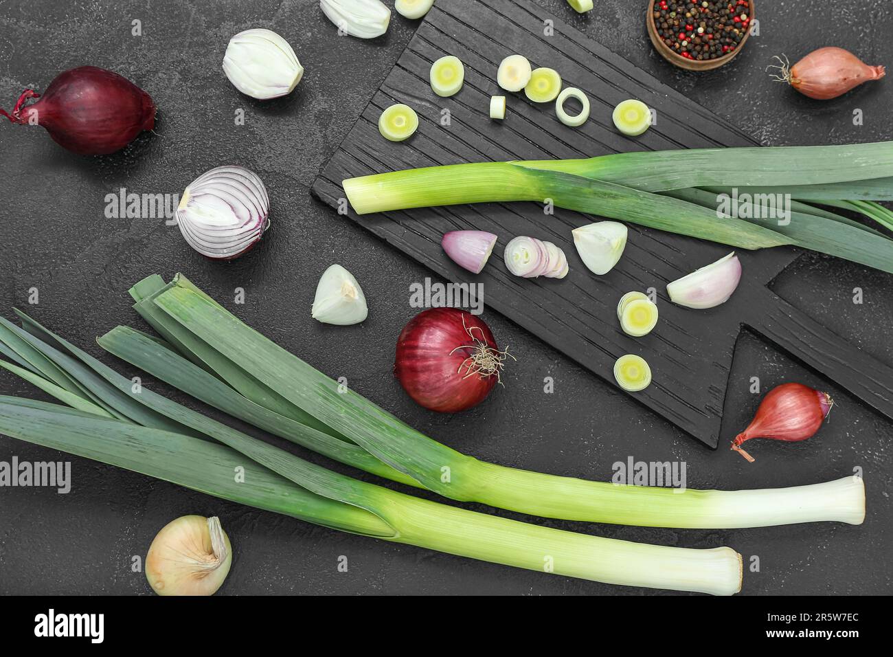 Board with different kinds of onion on grunge black background Stock ...