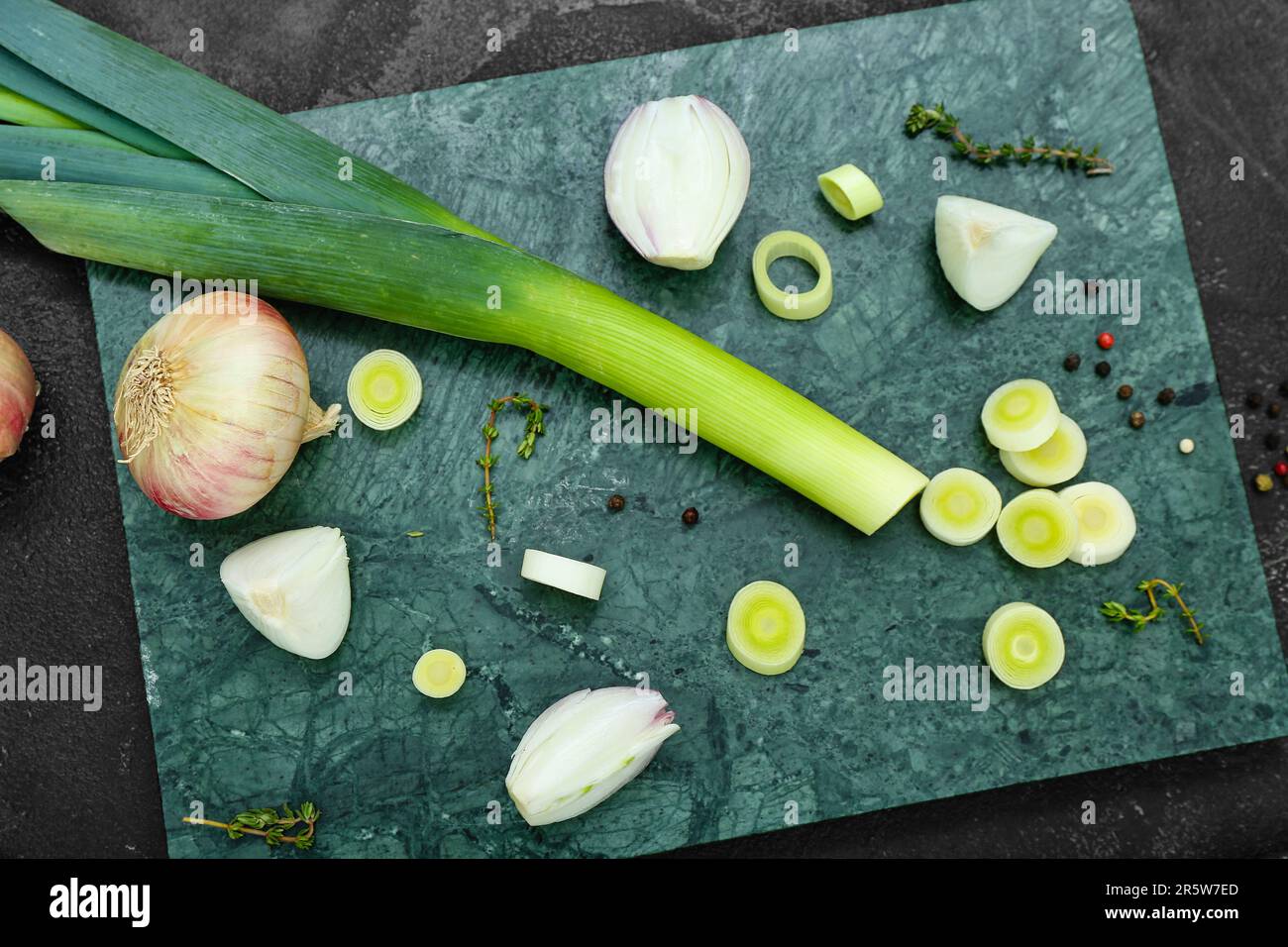 Board with different kinds of onion on grunge black background Stock ...