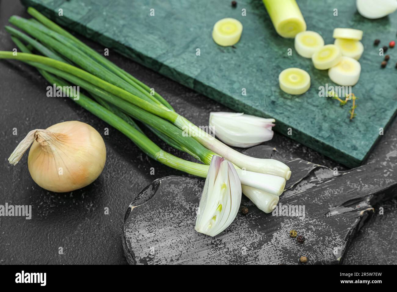 Boards with different kinds of onion on grunge black background Stock ...
