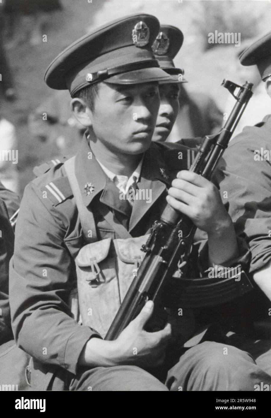A Chinese Soldier from the People Liberation Army grips his AK-47 machine gun while sitting on the back of a troop-carrying truck on the outskirts of Beijing on May 20, 1989. This was the first appearance of lethal weapons in the government's crackdown on pro-democracy protesters in Tiananmen Square. The army began to open fire on protesters in the early morning hours of June 4, 1989. Stock Photo