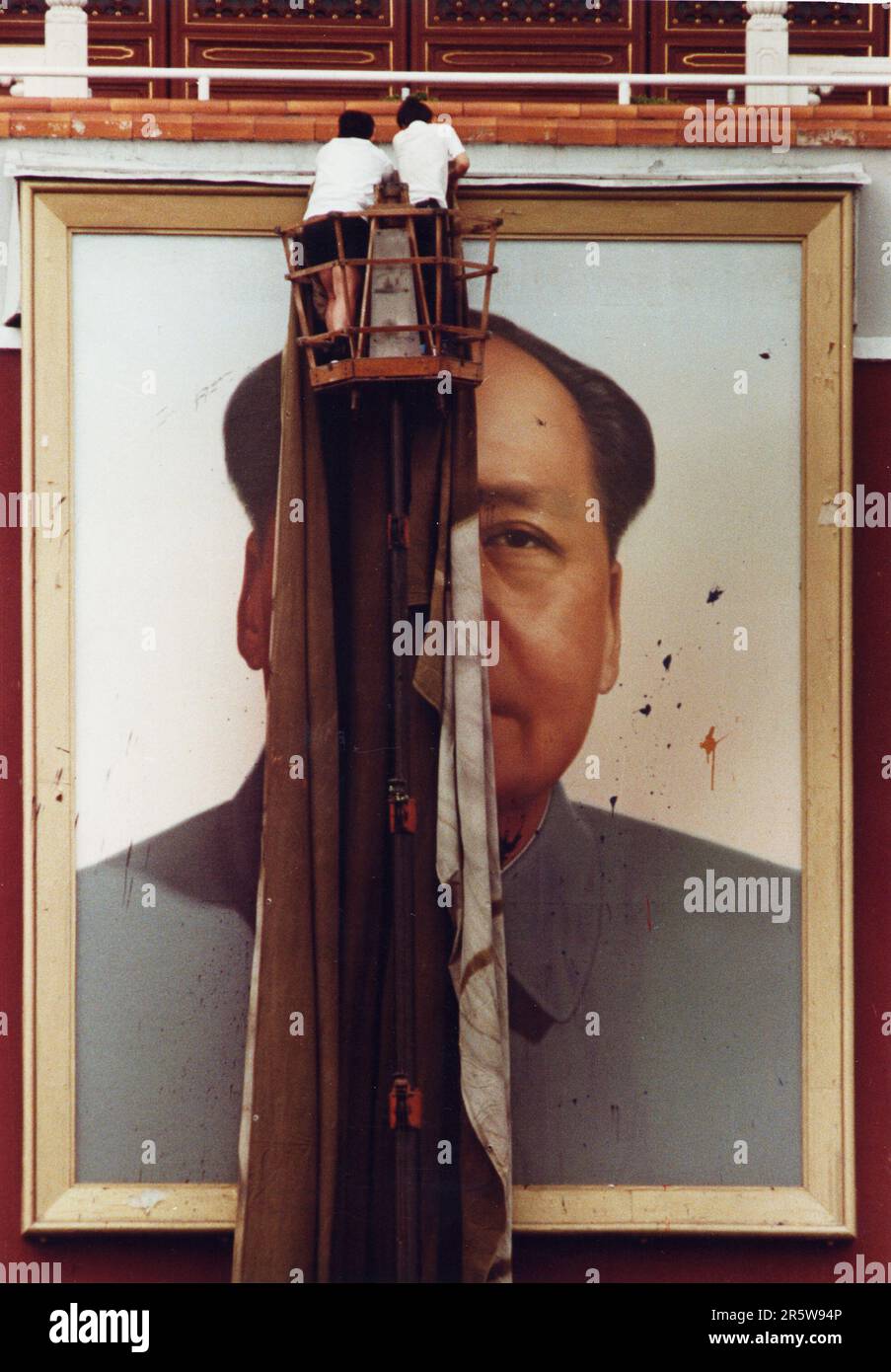 Workers cover the portrait of Chairman Mao presiding over Tiananmen Square after protesters defaced it with splatters of paint during pro-democracy demonstrations in 1989. Stock Photo