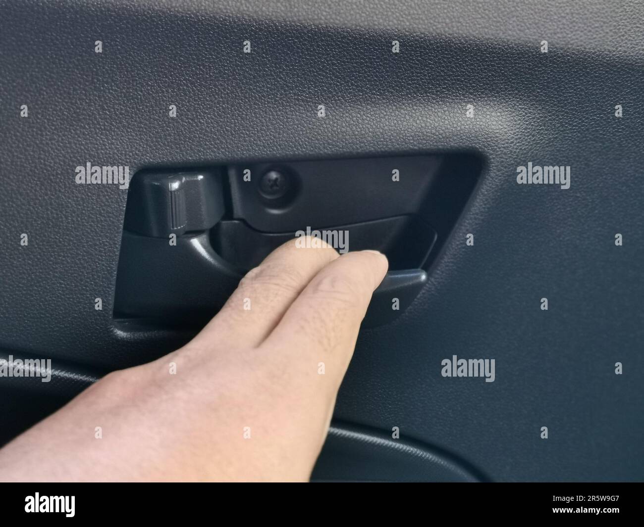 The hand touching a car door handle. Car interior details Stock Photo