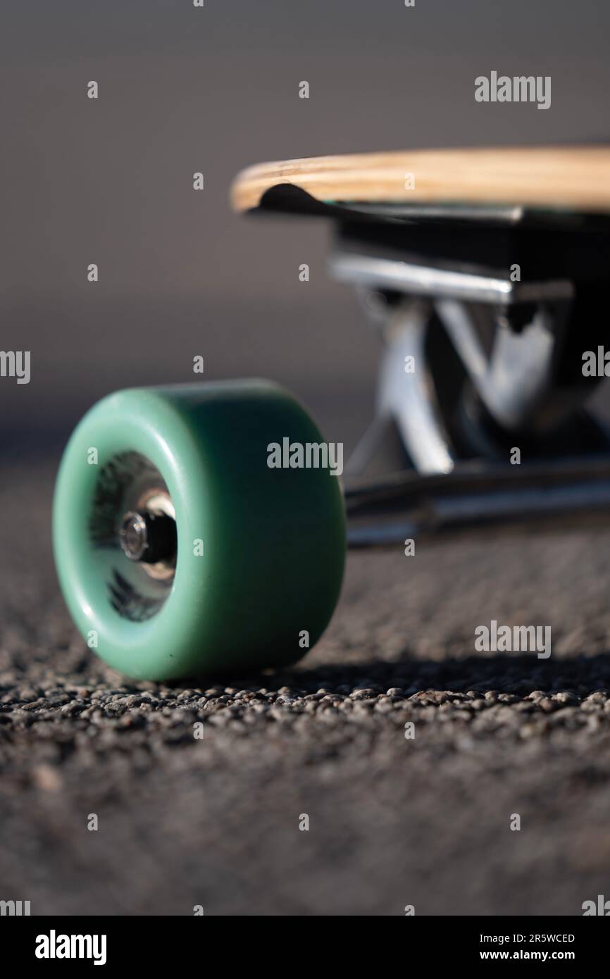 A skateboard lying abandoned on a pavement, its wheels detached and its