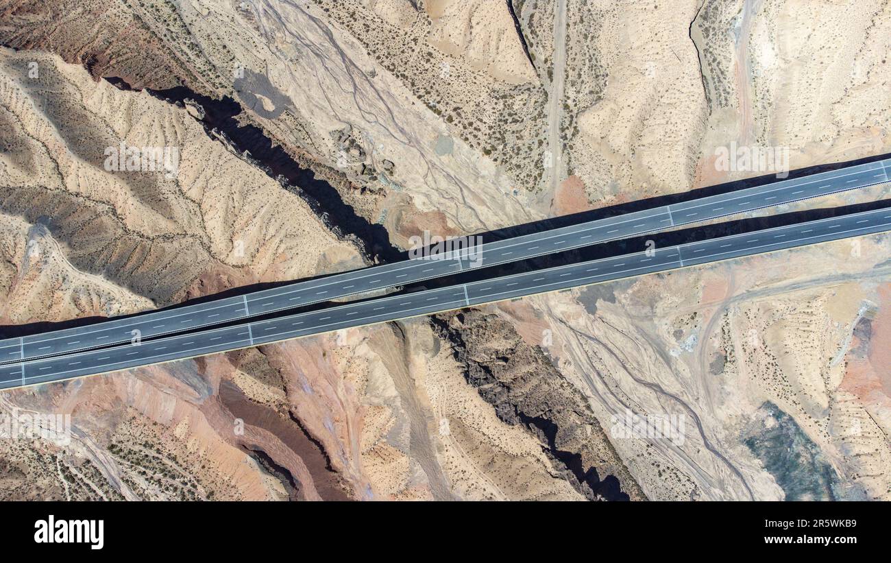Aerial view of two roads intersecting in a desert mountain landscape ...