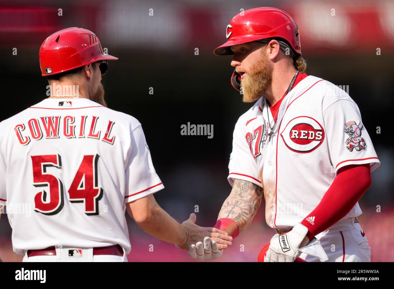 Cincinnati Reds' Jake Fraley (27) celebrates with first base coach Collin Cowgill (54) after