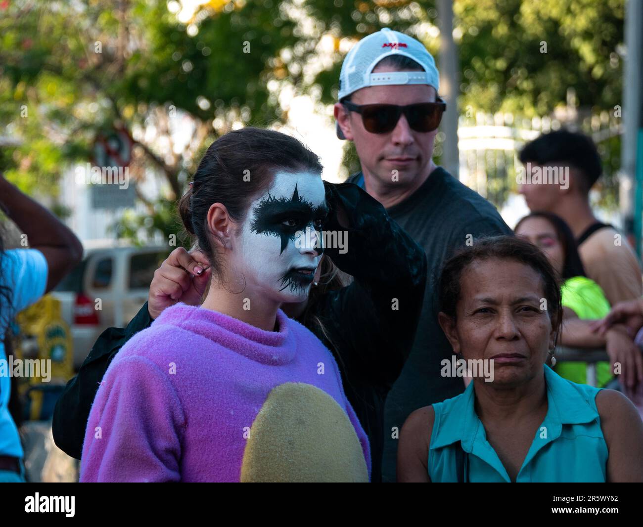 Barranquilla, Atlantico, Colombia - February 21 2023: Young Colombian Woman with White Face Paint and Black Eyes is Wearing a Purple Costume at Carniv Stock Photo