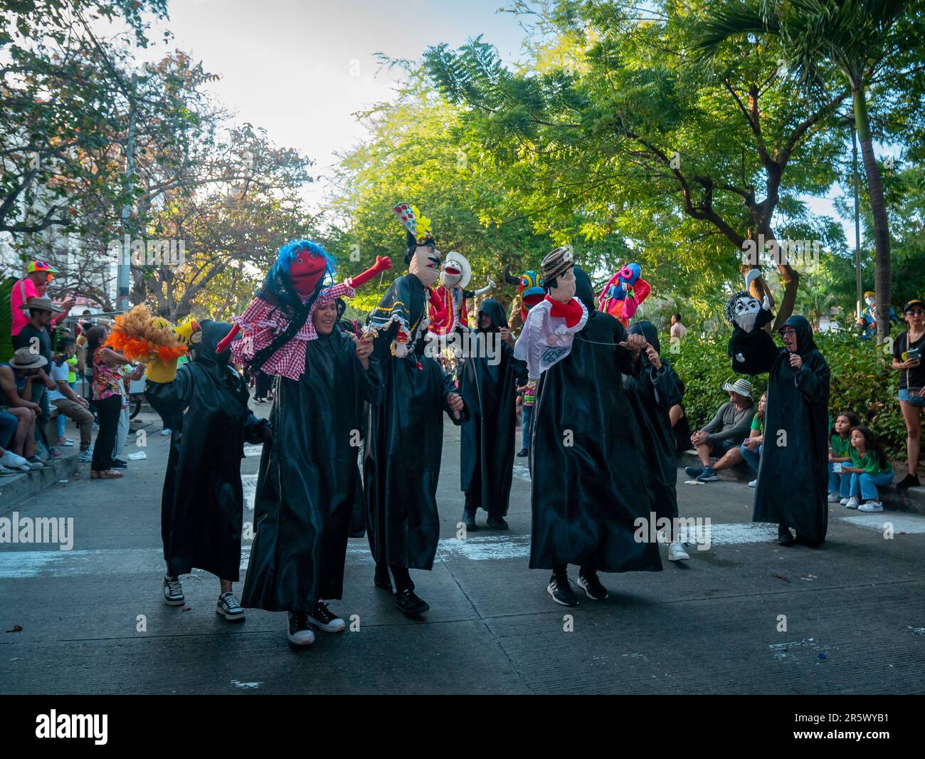 Barranquilla, Colombia - February 21 2023: Colombian Men y Women Wear Black Costumes Parade Dancing with Puppets at the Famous Carnival of Barranquill Stock Photo