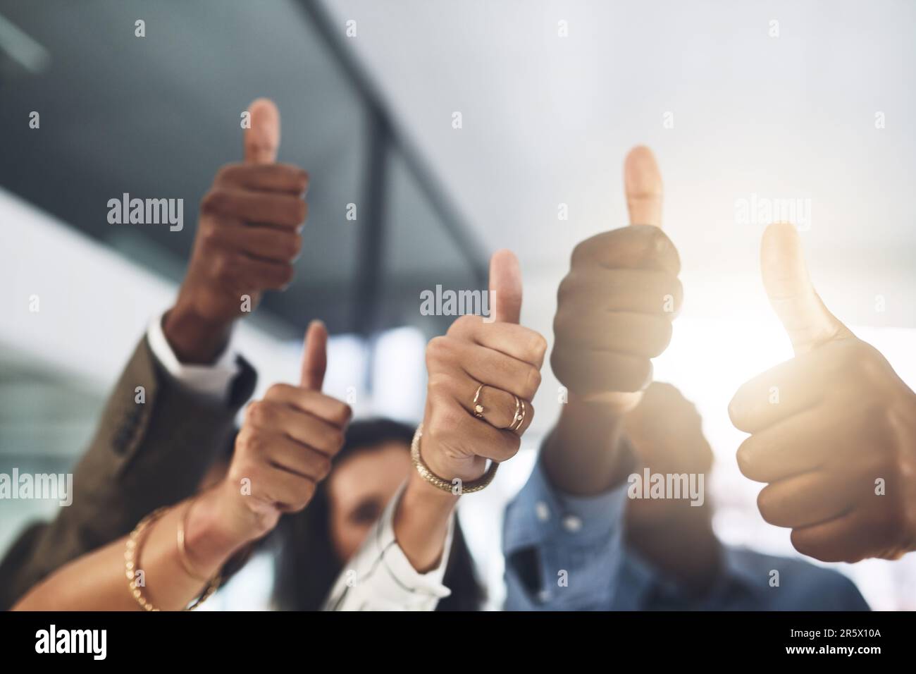 You should be proud of your achievements. Closeup shot of a group of businesspeople showing thumbs up in an office. Stock Photo
