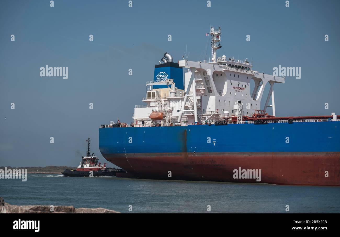 PORT ARANSAS, TX - 26 FEB 2023: A tugboat assists the YUAN FU YANG, an Oil Products Tanker Ship as it sails toward the Gulf of Mexico on the shipping Stock Photo
