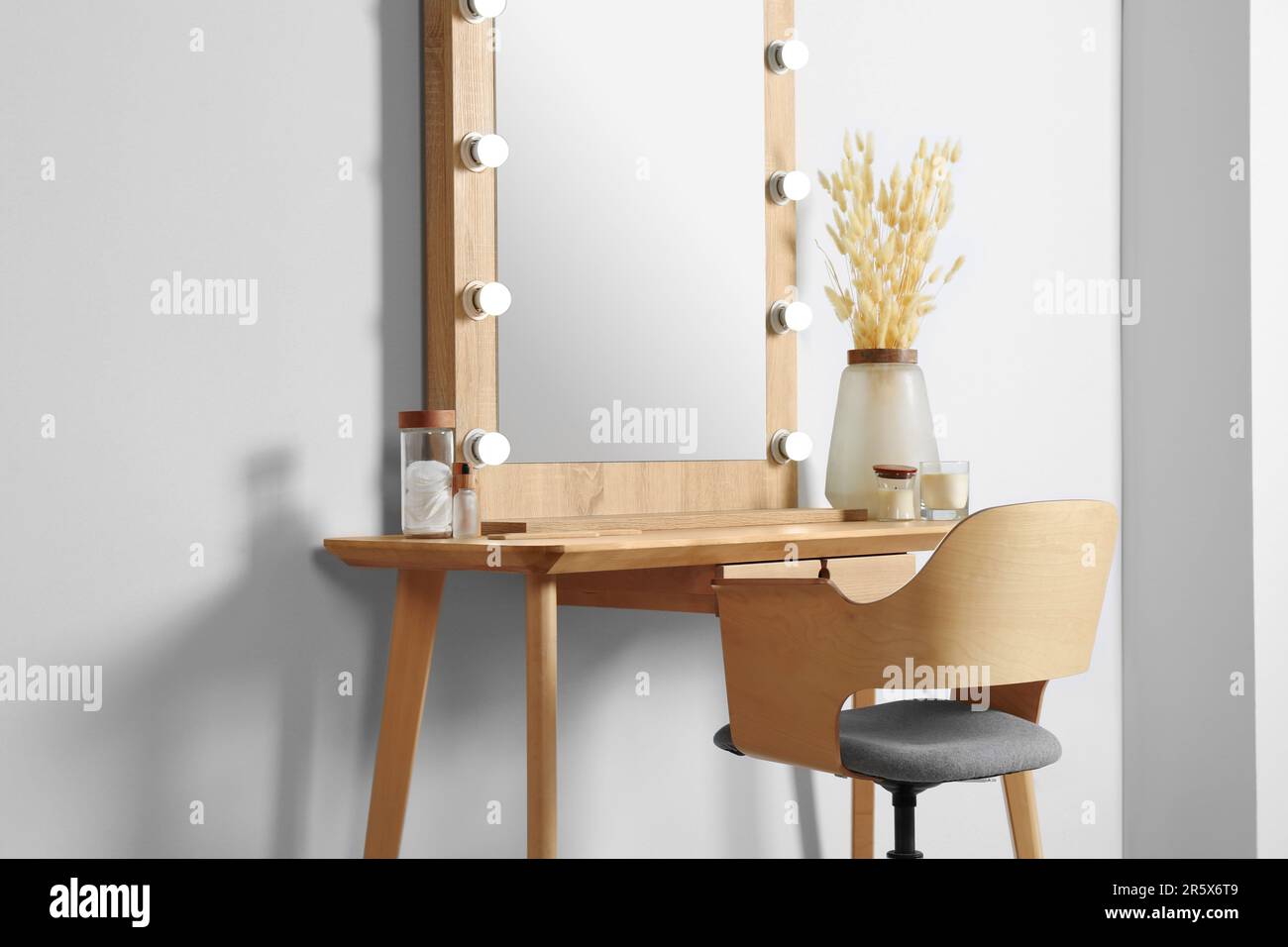 Dressing table with stylish mirror, dried reeds and other decorative ...
