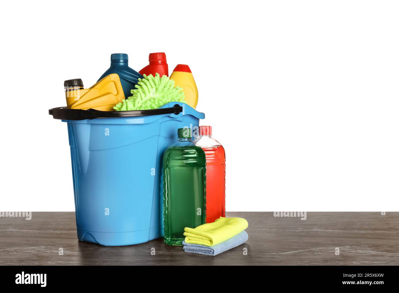 Light blue bucket and many different car wash products on black wooden