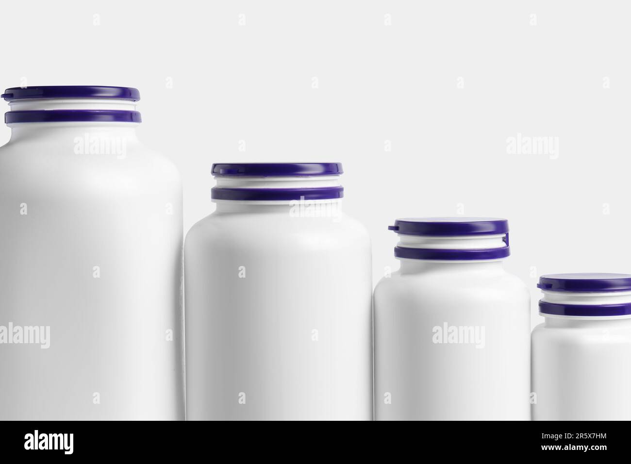 Row of different plastic medicine bottles on white background ...