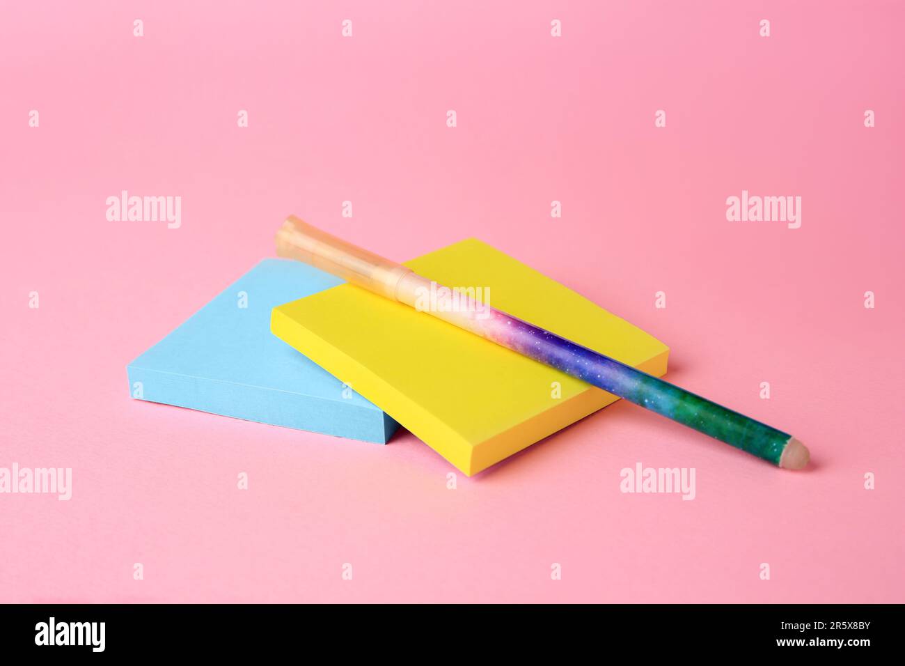 Colorful paper notes with erasable pen on pink background, closeup ...