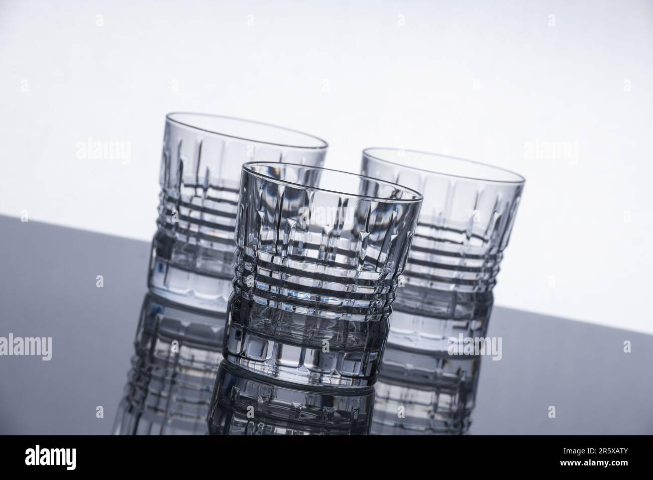 Crystal whiskey glasses on a reflective surface. Isolated object