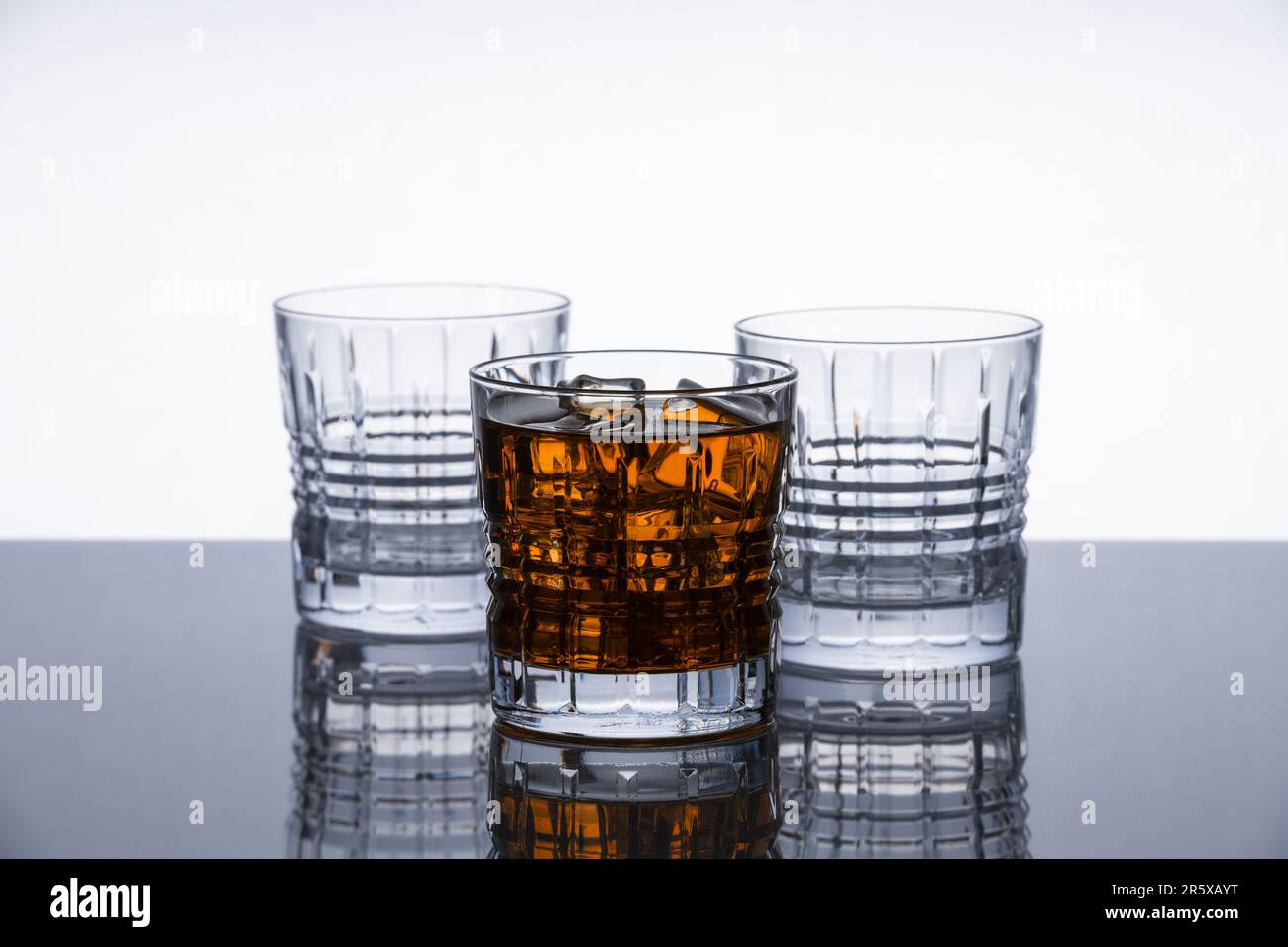 Crystal whiskey glasses on a reflective surface. Isolated object