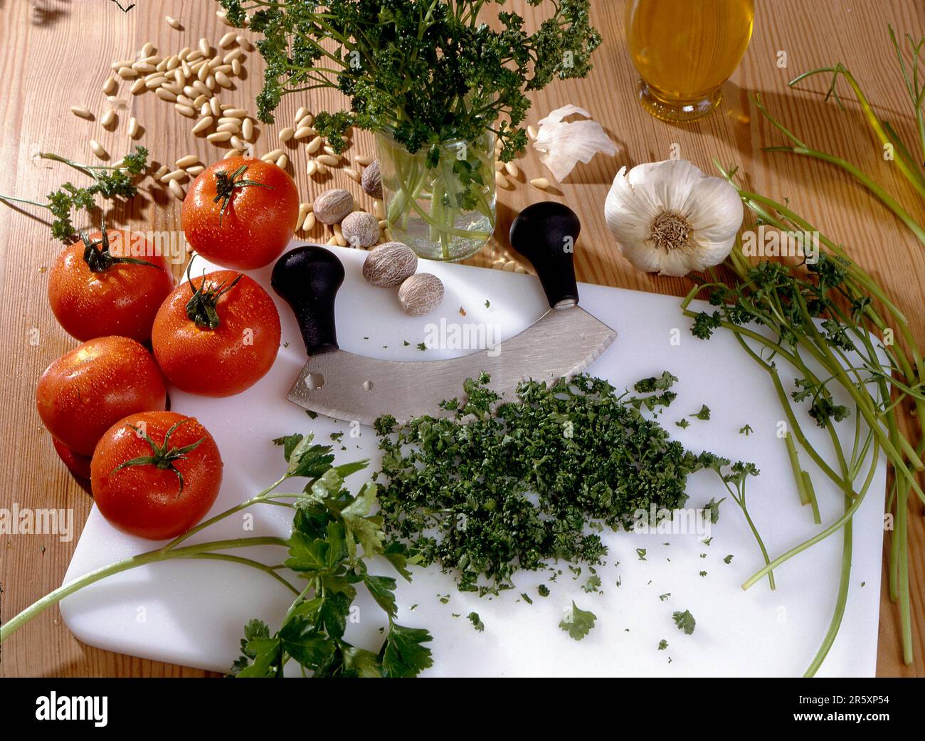 Chopping board, chopping knife Parsley, tomatoes, nutmeg, pine nuts