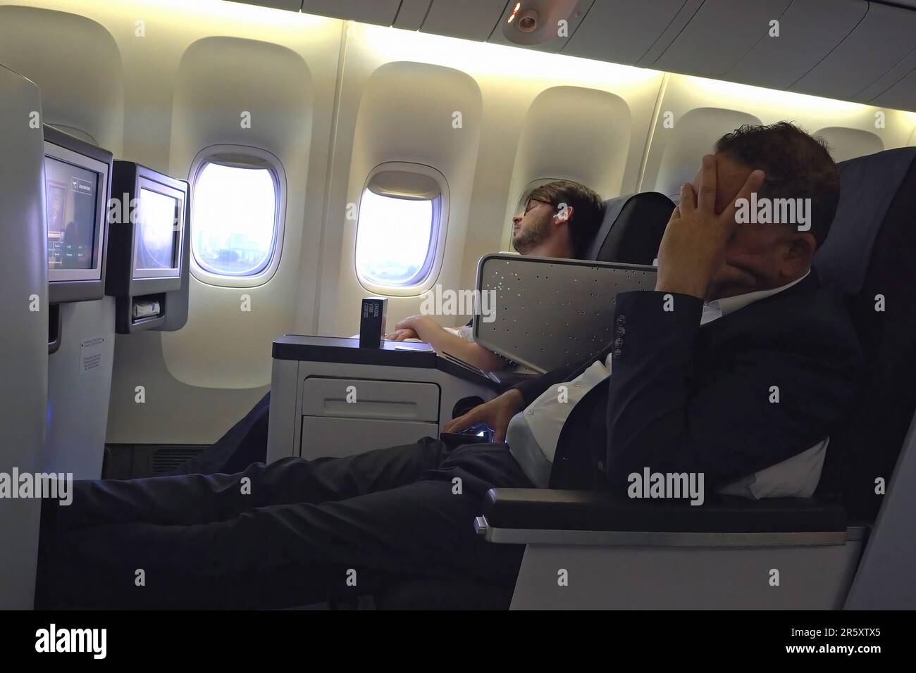 A passenger sleeps during flight at the Business class cabin of Boeing