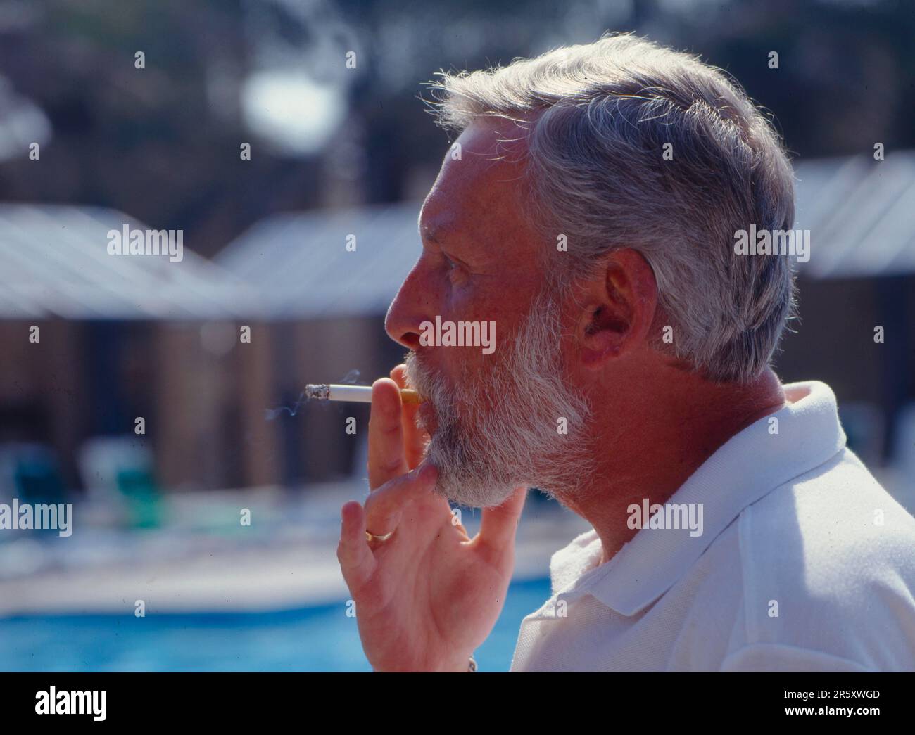 Smoking man, pulls on cigarette, cigarette in mouth Stock Photo