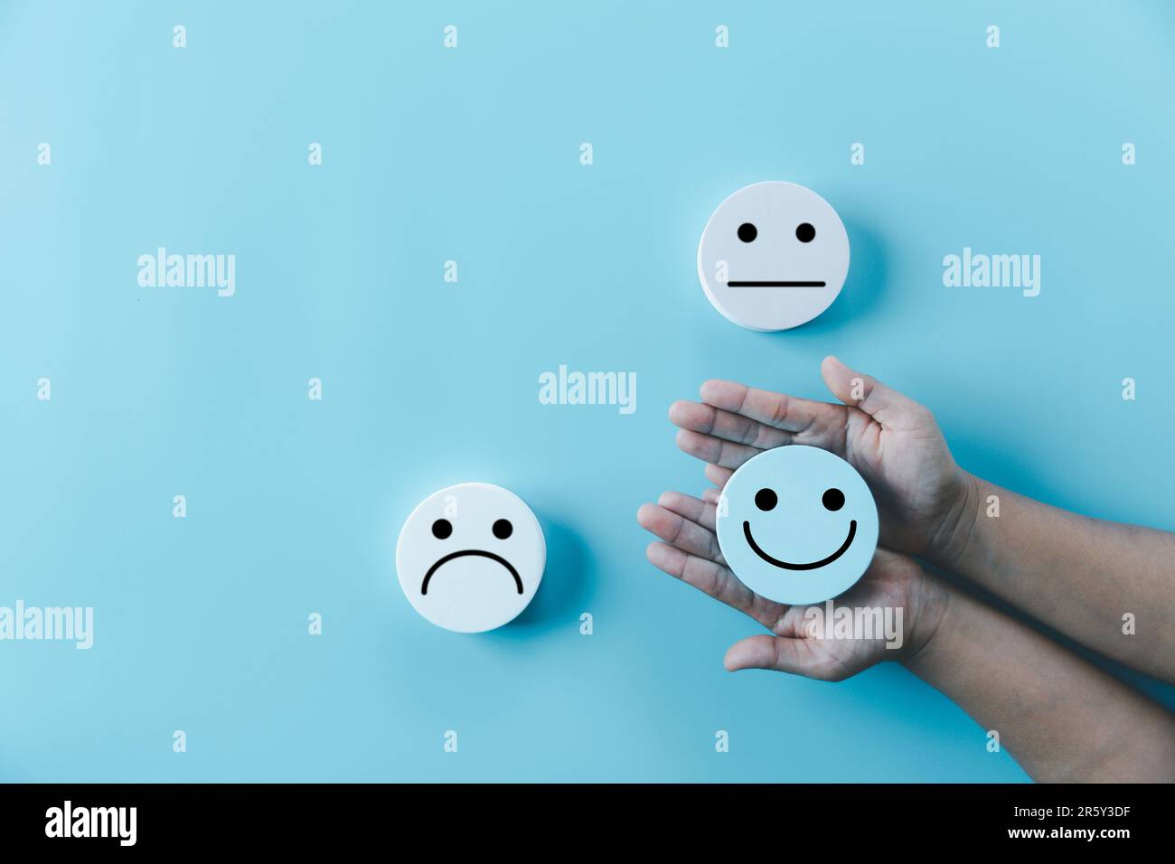 Woman hand holding happy face smile face icon on round blue object ...