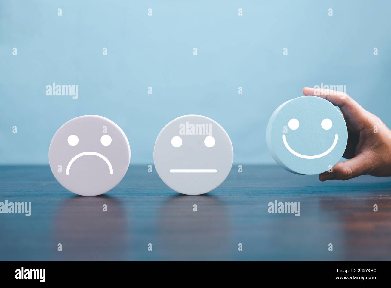 Woman hand holding happy face smile face icon on round blue object ...