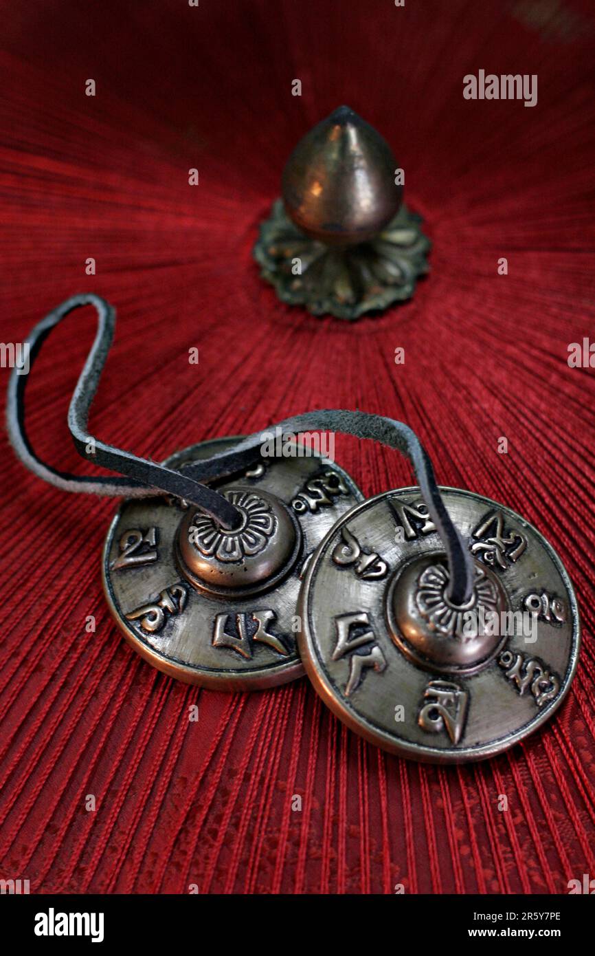 Tingsha are small cymbals used in prayer and rituals by Tibetan Buddhist practitioners. Two cymbals are joined together by a leather strap Stock Photo