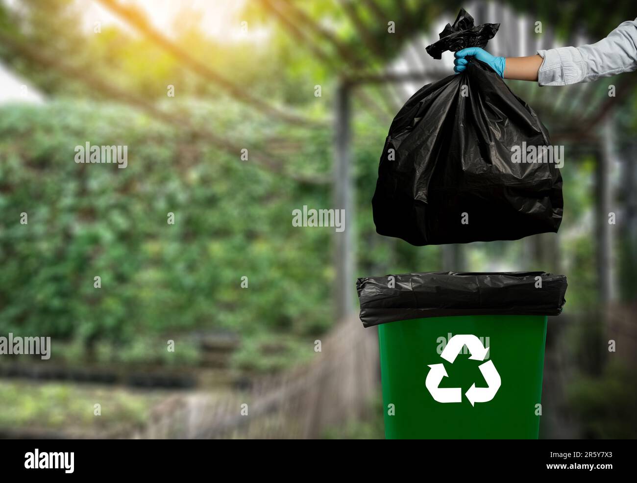 Manhand garbage putting plastic and glasses in reuse bin trash for