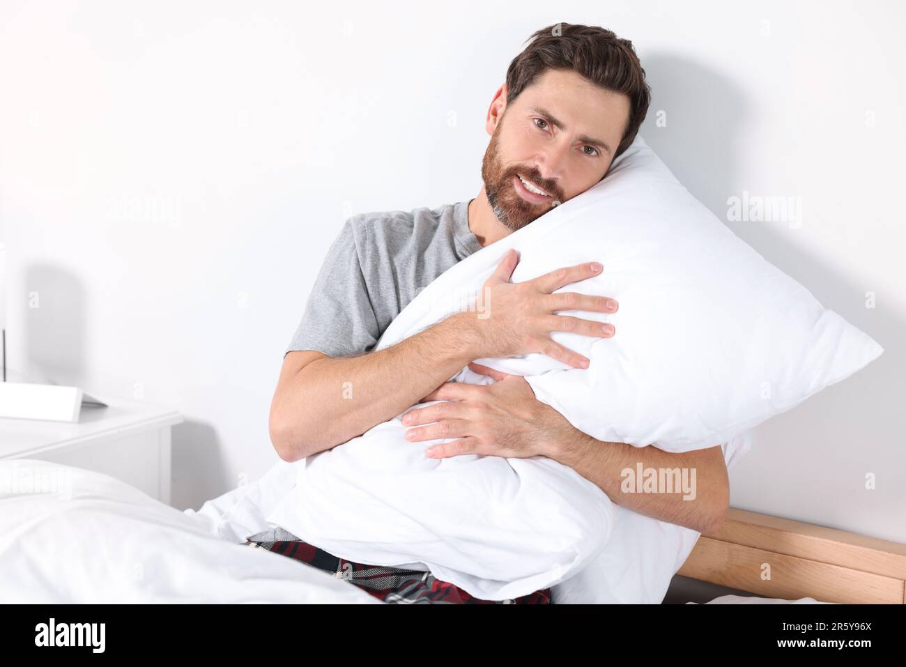 https://c8.alamy.com/comp/2R5Y96X/man-hugging-pillow-on-bed-at-home-2R5Y96X.jpg