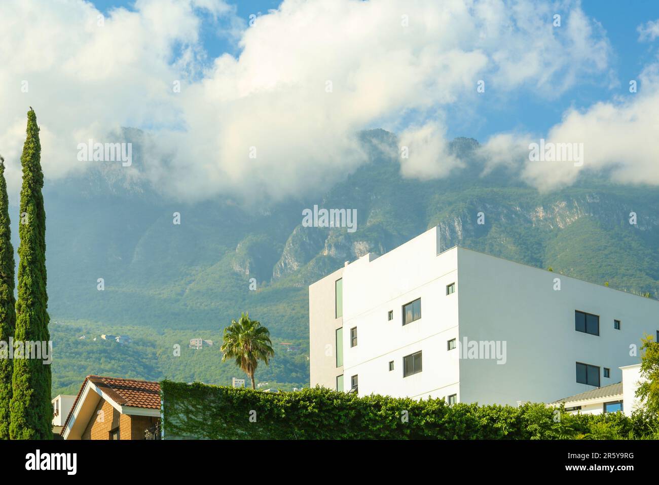 Beautiful view of building near mountains under cloudy sky Stock Photo