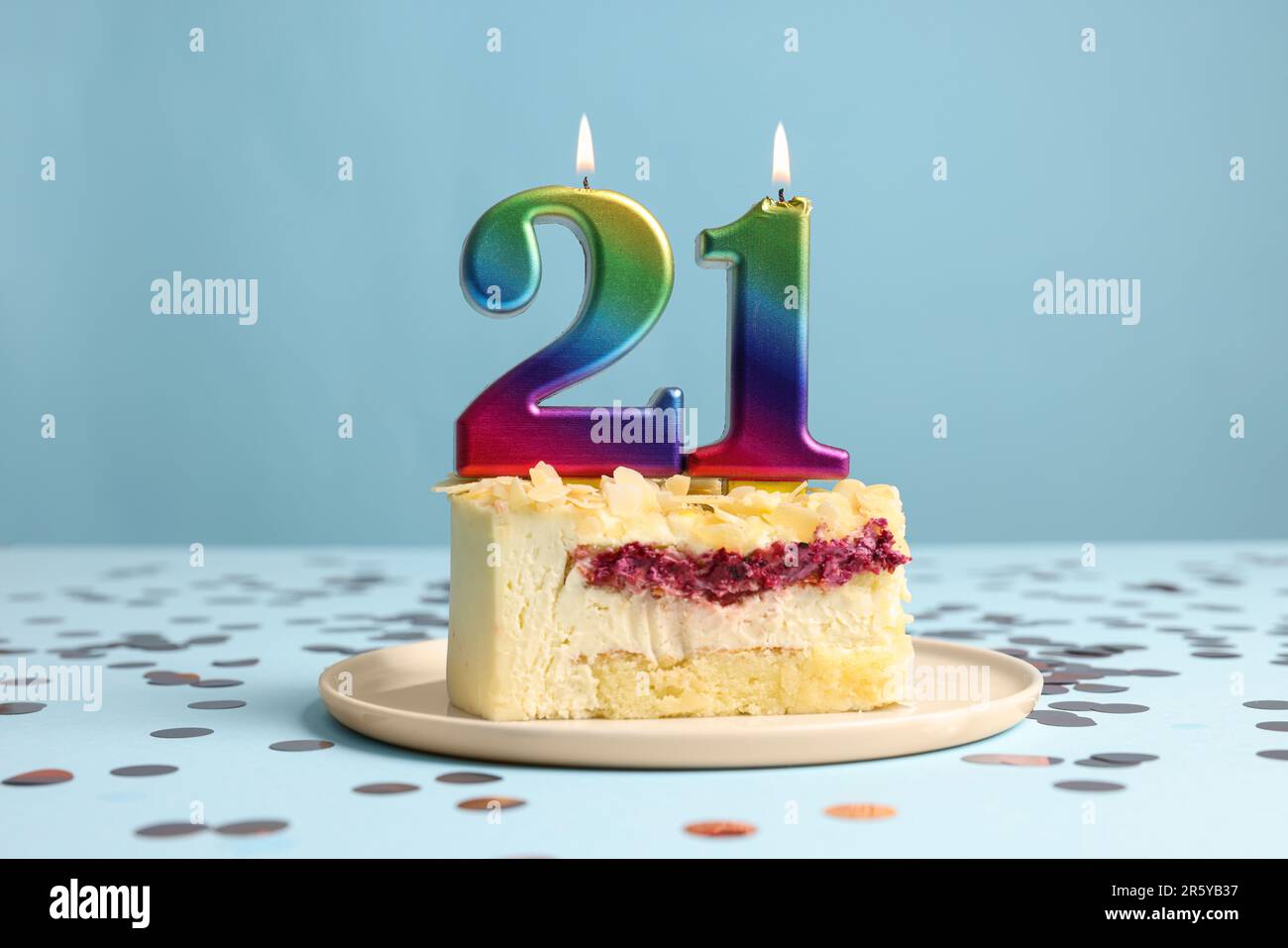 Coming of age party - 21st birthday. Delicious cake with number shaped candles on light blue background Stock Photo