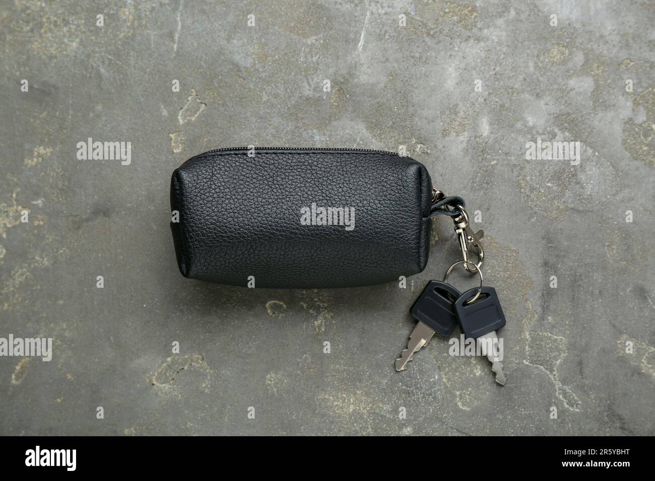 Leather case with keys on grey textured table, top view Stock Photo