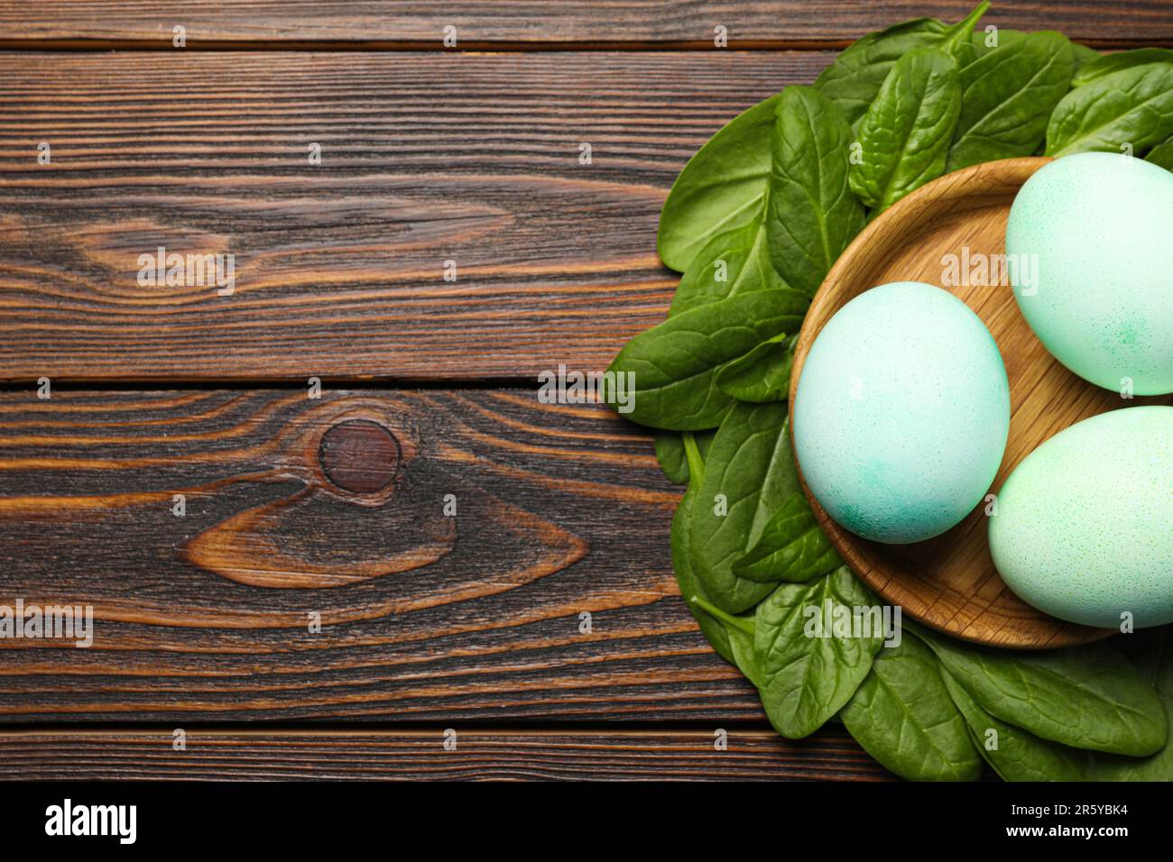 Naturally painted Easter eggs and space for text on wooden table, flat ...