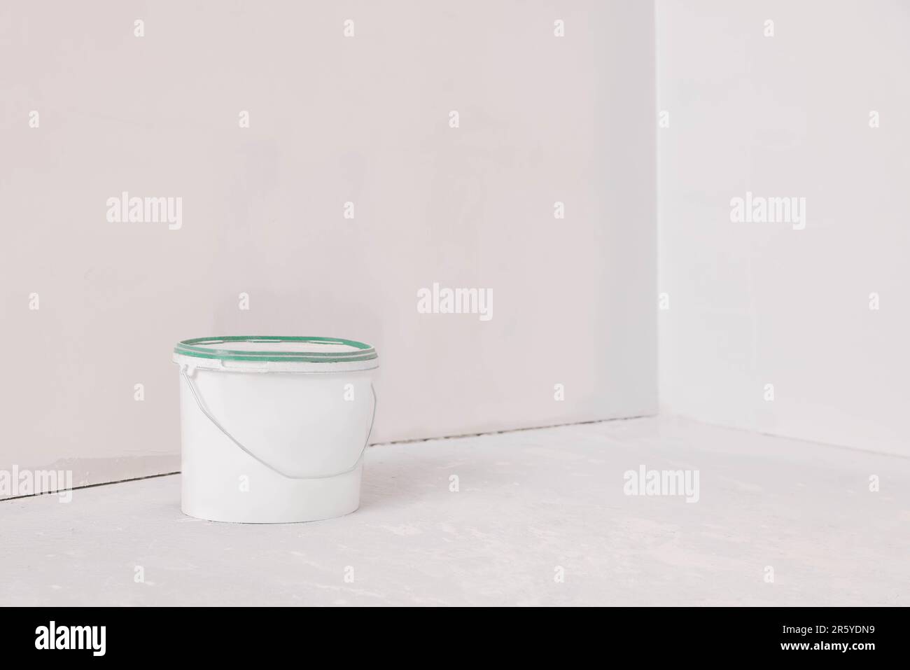 Bucket Left Bucket with paint in empty room, space for text Stock Photo - Alamy