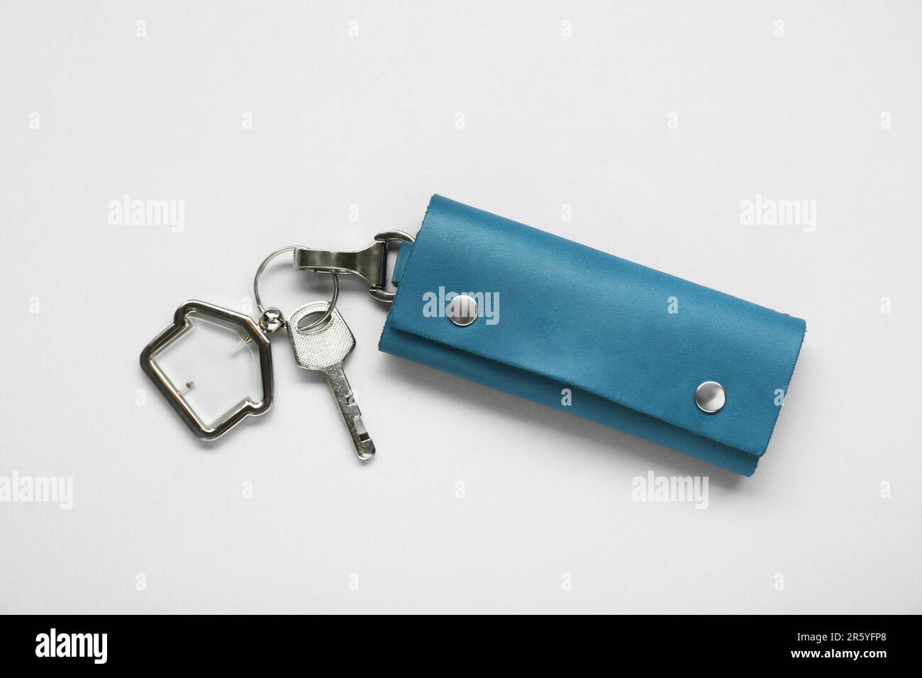 Leather case with key on light grey background, top view Stock Photo