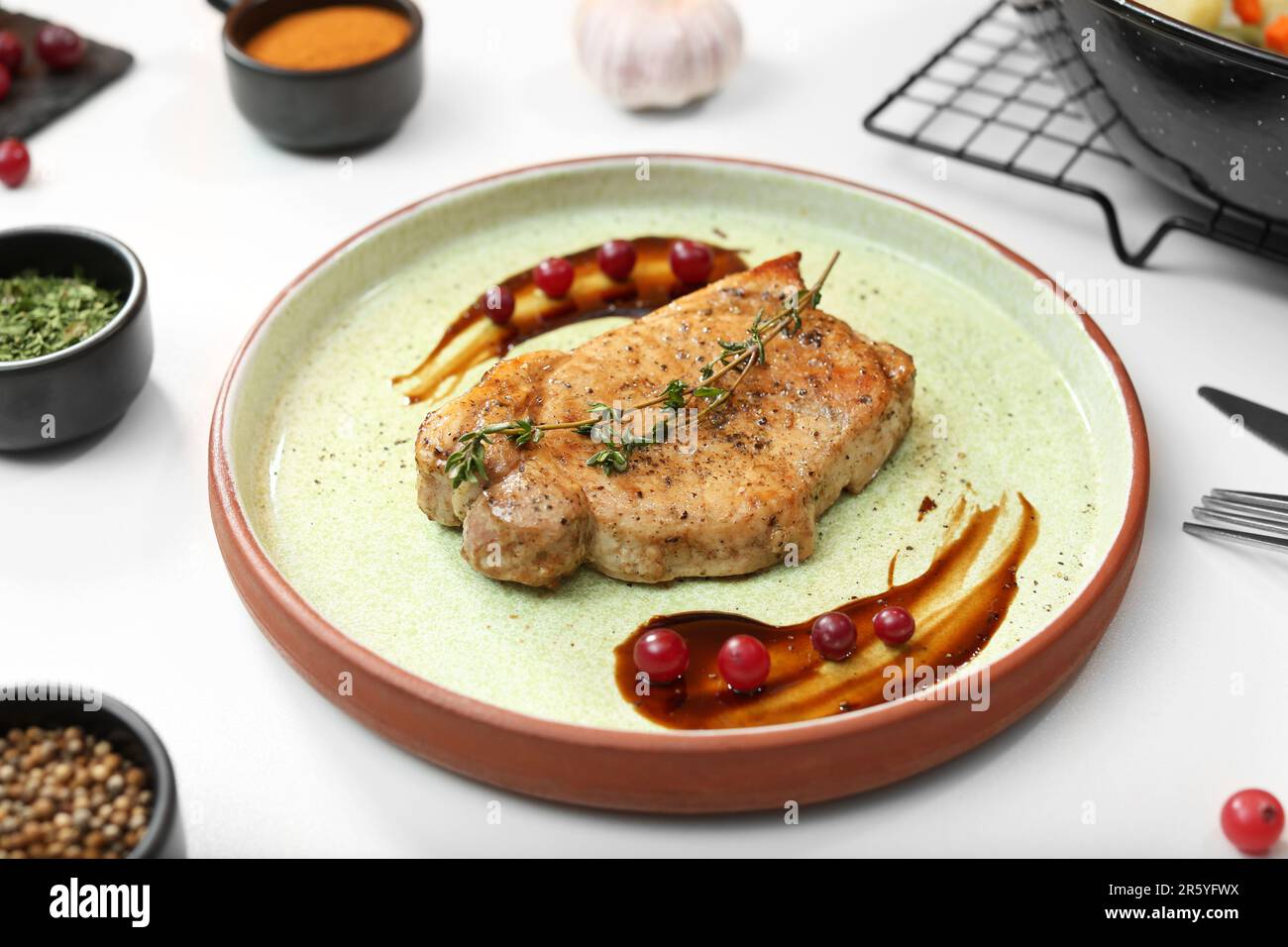 Beautiful composition with plate of delicious meat on white table in studio. Food stylist Stock Photo
