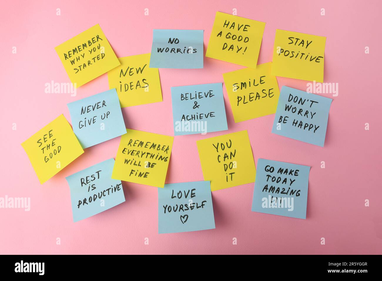 Paper notes with life-affirming phrases on pink background Stock Photo