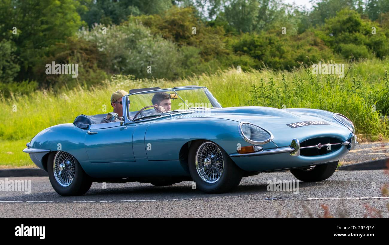 Stony Stratford,UK - June 4th 2023: 1967 BLUE JAGUAR E-TYPE classic car travelling on an English country road. Stock Photo