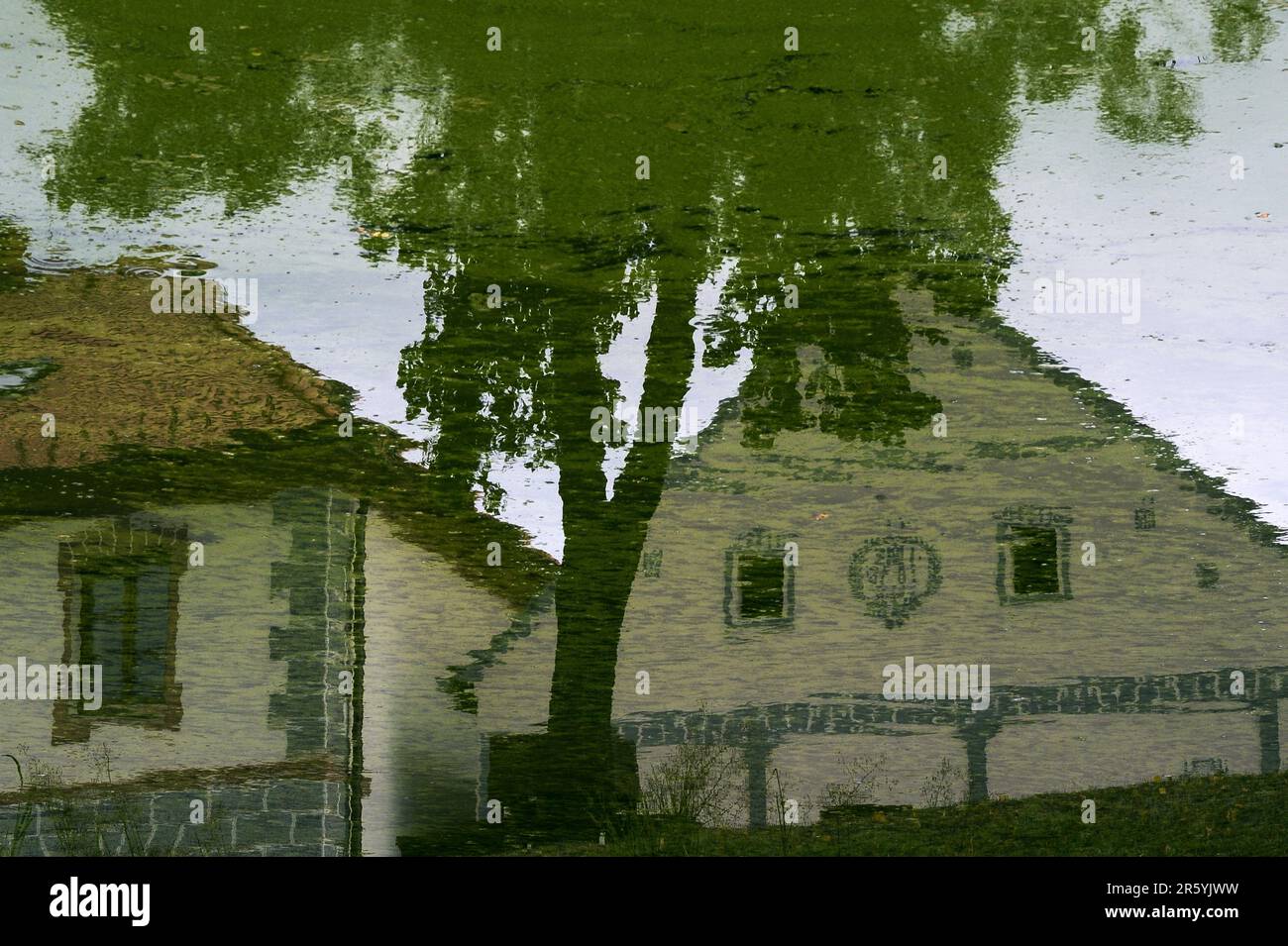 This image has been rotated by 180 degrees.  Houses in Holašovice, South Bohemia, Czech Republic or Czechia, reflected in the still water of a pond on the village green.  Holašovice is a well-preserved example of a traditional Central European village with a ground plan dating from the Middle Ages and a number of 1700s AD and 1800s AD vernacular buildings in a style known as South Bohemian Folk Baroque, Rural Baroque or Rustic Baroque.  In 1997 the village was included in the UNESCO World Cultural Heritage List. Stock Photo