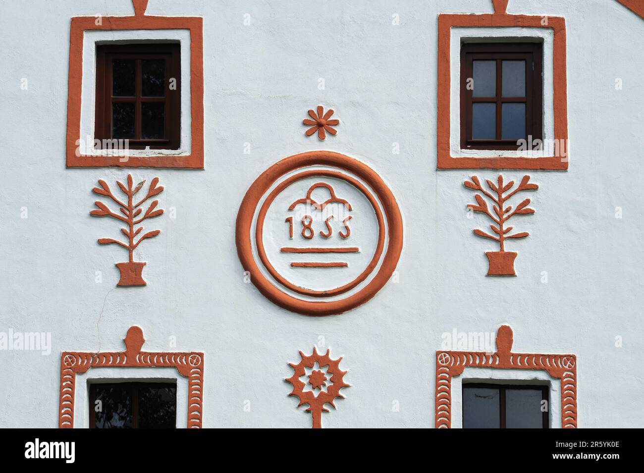 Stucco decoration on front of house in Holašovice, South Bohemia, Czech Republic or Czechia, displays the date of the house’s foundation, 1855.  Holašovice is a well-preserved example of a traditional Central European village with many farmers’ houses rebuilt in the 1800s AD in a style known as South Bohemian Folk Baroque, Rural Baroque or Rustic Baroque.   In 1997 the village was included in the UNESCO World Cultural Heritage List. Stock Photo