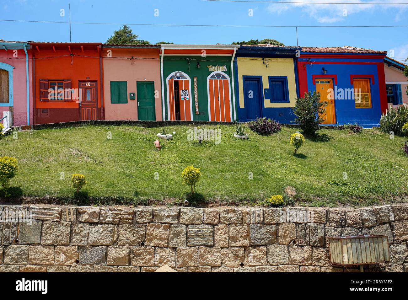 Colorful row of house facades and green space with blue sky in historical town São Luíz do Paraitinga, Brazil Stock Photo