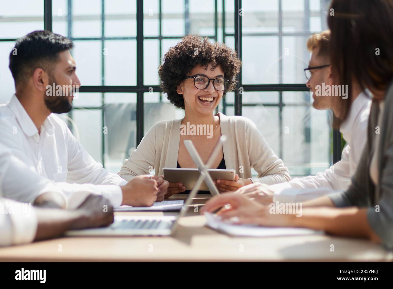 Employees working at computer together, discussing content Stock Photo