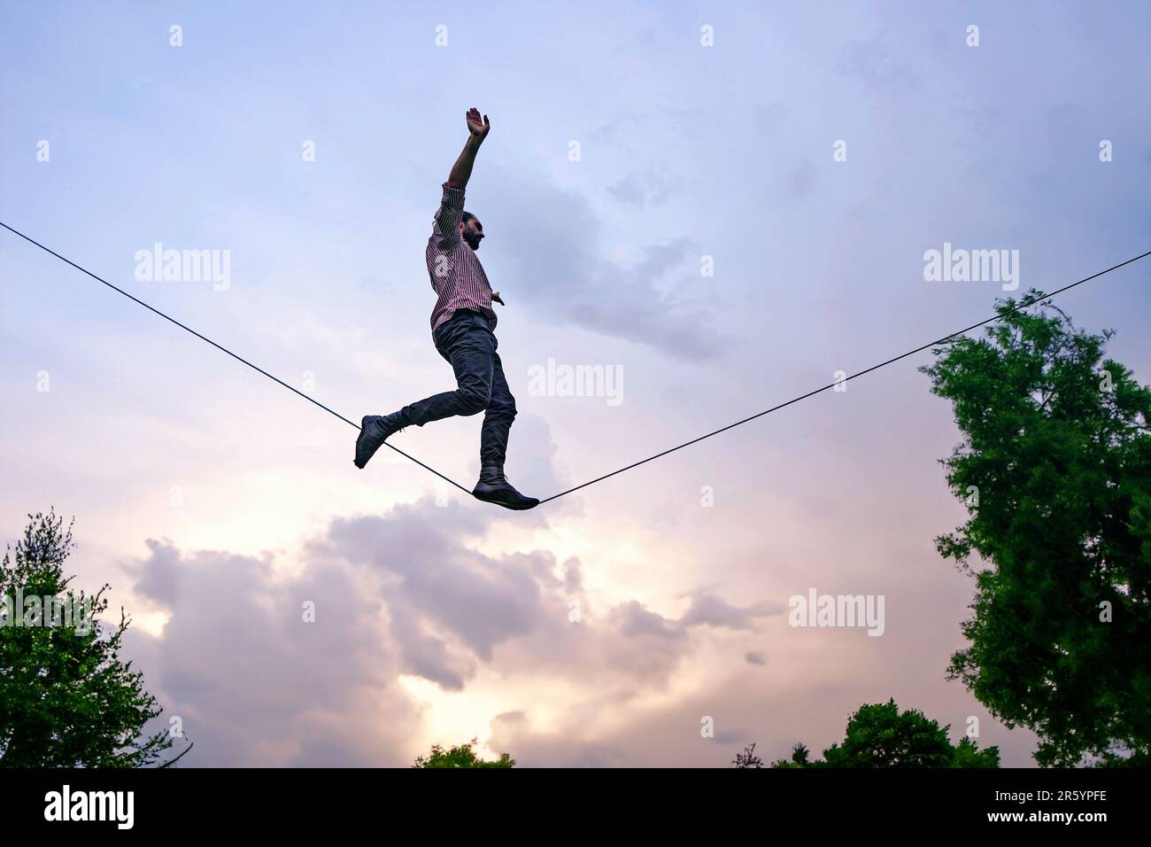 Rope walker during an outdoor circus show. Milan, Italy - April 2023 Stock Photo