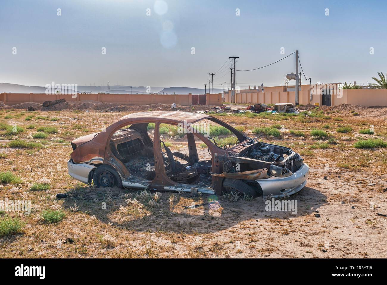 Burnt-out Car in Desert Stock Photo