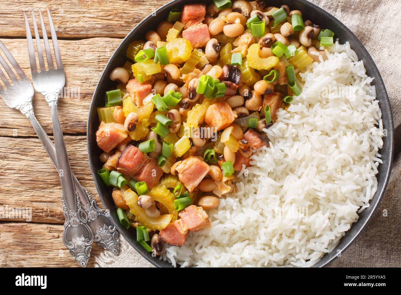 Homemade Hoppin john Southern style New year good luck food is a black-eyed peas and rice with vegetables dish closeup on the plate on the wooden tabl Stock Photo