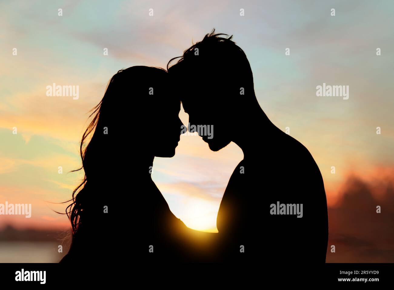 Silhouette of lovely couple enjoying each other at sunset Stock Photo ...